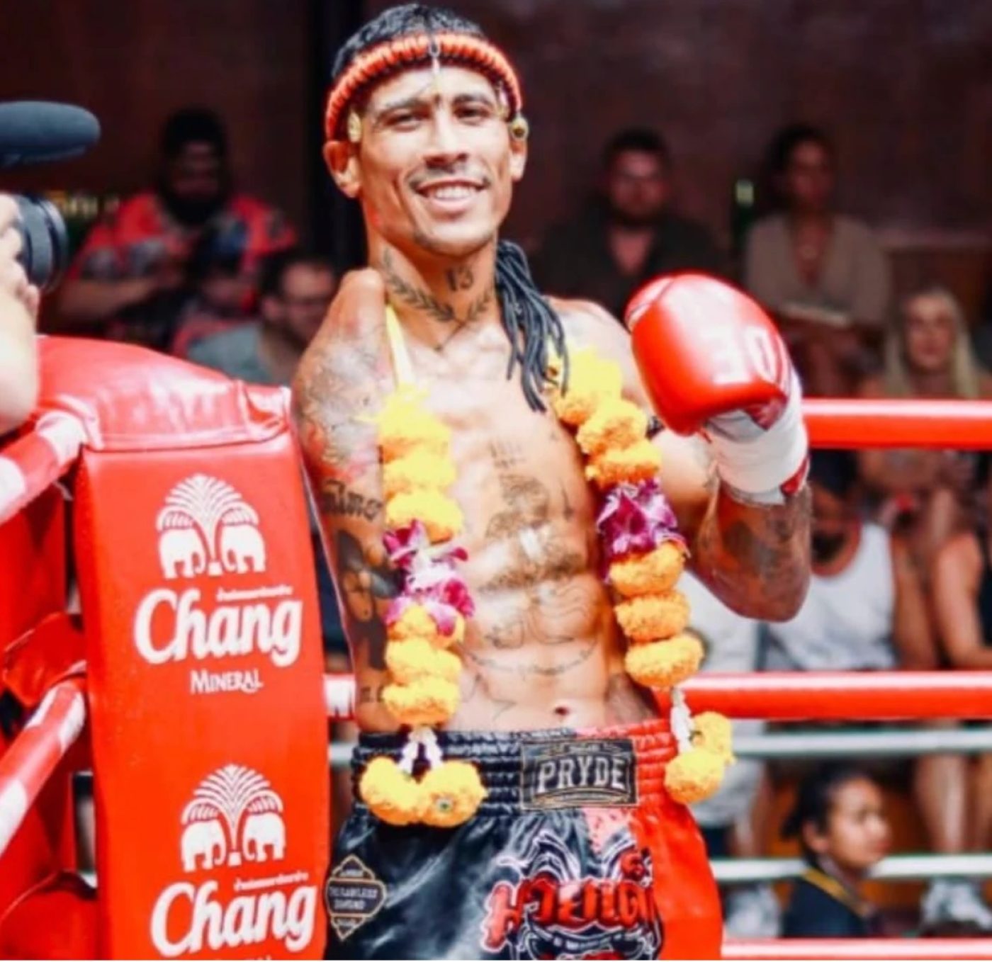 Carlitos Machado smiling in the ring with a garland and his glove raised